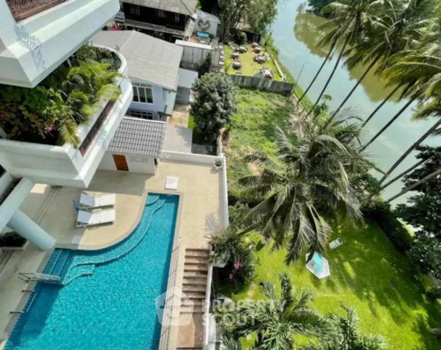Luxurious riverside property with pool and lush garden view