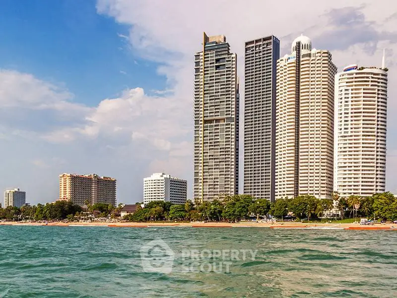 Stunning beachfront high-rise buildings with ocean view and lush greenery.