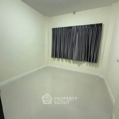 Spacious empty room with tiled flooring and large window with curtains, perfect for customization.