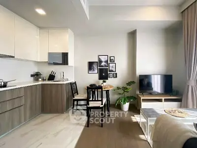 Modern open-layout living room with stylish kitchen and dining area, featuring sleek cabinetry and cozy decor.