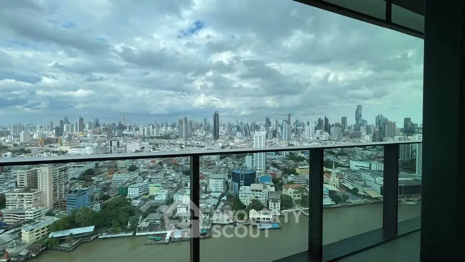 Stunning cityscape view from high-rise balcony overlooking river and skyline.