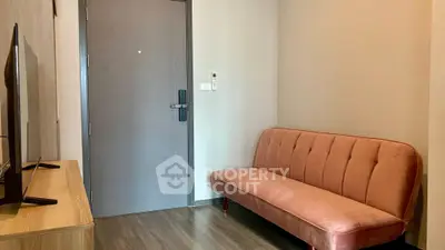 Cozy living room with modern sofa and flat-screen TV, perfect for relaxation.