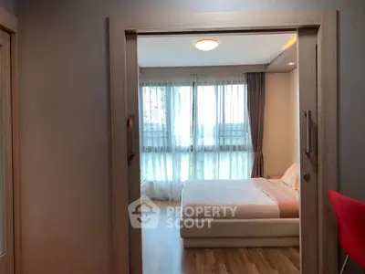 Cozy bedroom with large window and modern decor in a stylish apartment.