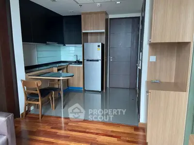 Modern kitchen with sleek cabinetry and dining area in stylish apartment