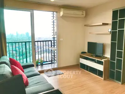 Modern living room with city view and balcony access, featuring stylish furniture and air conditioning.