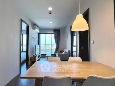 Modern open-plan living room with dining area and city view