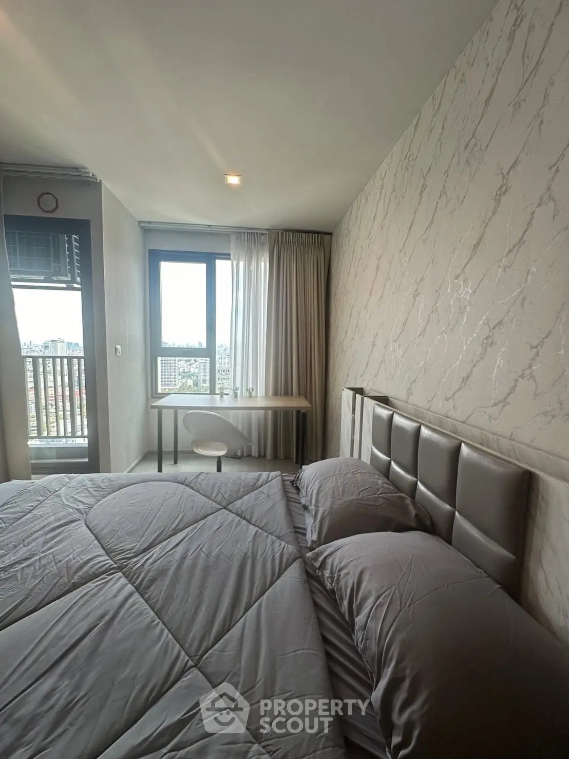 Modern bedroom with stylish decor and city view from window