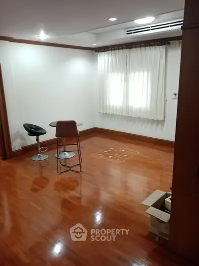 Spacious room with wooden flooring and modern bar stools