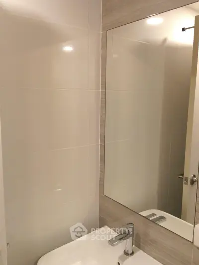 Modern bathroom with sleek sink and large mirror, perfect for contemporary living.