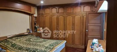 Spacious bedroom with wooden built-in wardrobes and cozy decor