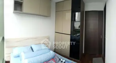 Modern bedroom with sleek wardrobe and cozy bedding in a stylish apartment.