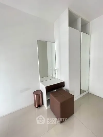 Modern minimalist bedroom with sleek wardrobe and stylish vanity area.