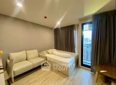 Modern living room with cozy sofa and bed, featuring a balcony with city view.