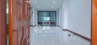 Spacious open-plan living area with elegant marble flooring and glass partition.