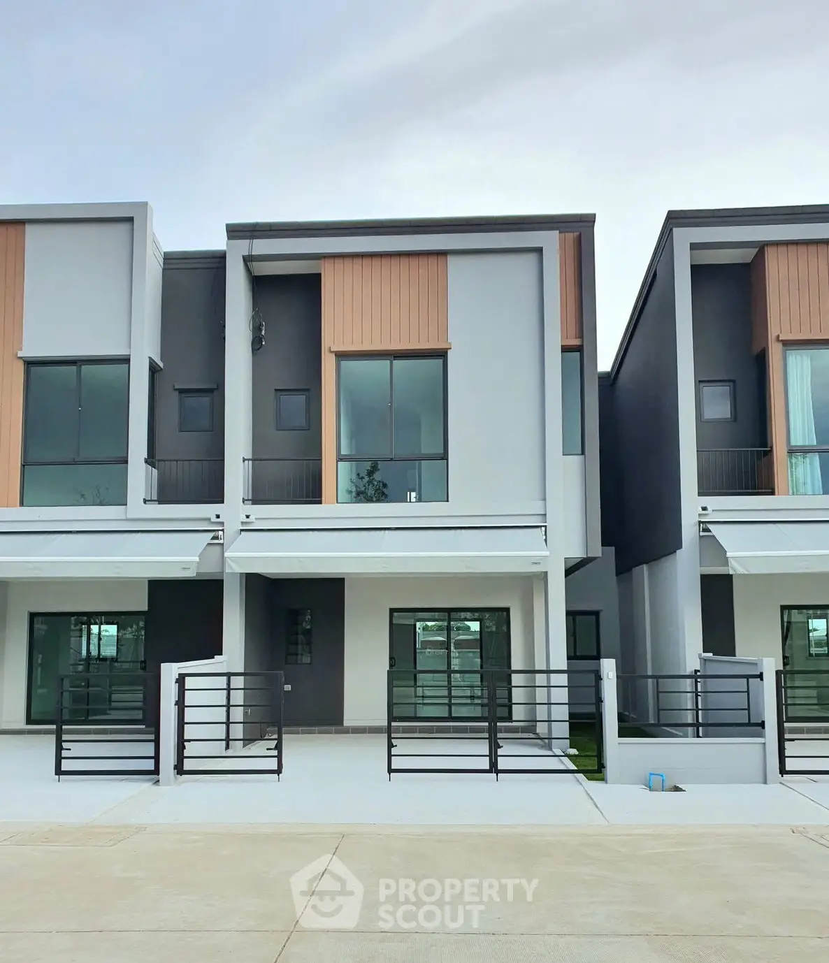 Modern townhouse exterior with sleek design and large windows in a suburban setting.