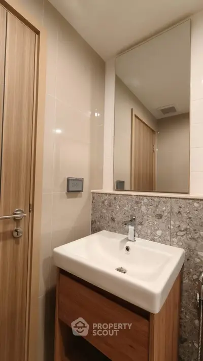 Modern bathroom with sleek sink and wooden accents, perfect for contemporary living.