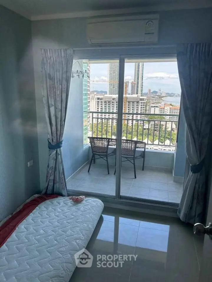 Cozy bedroom with balcony offering stunning cityscape views