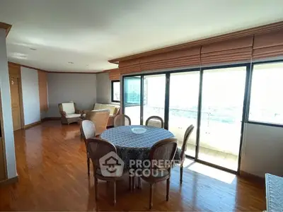 Spacious living room with dining area and large windows offering a stunning view.