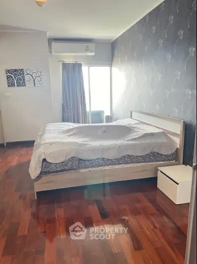 Spacious bedroom with elegant decor and natural light in modern apartment.