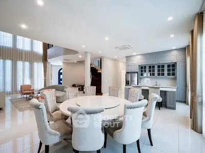 Luxurious open-plan living and dining area with elegant furnishings and modern kitchen.