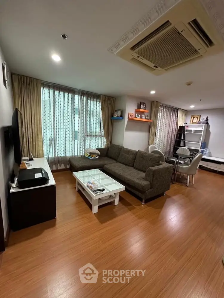 Spacious living room with modern decor and large windows in a stylish apartment.