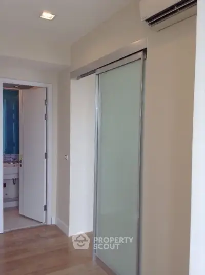 Modern interior with sliding door and air conditioning, featuring sleek design and wooden flooring.