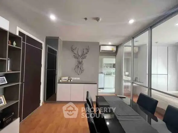 Modern dining area with sleek decor and open view into kitchen