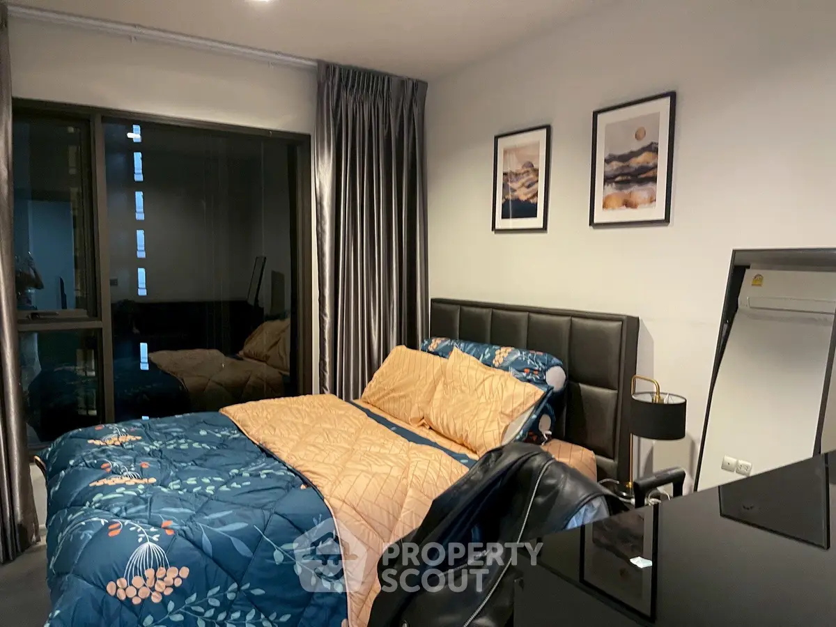 Cozy modern bedroom with stylish decor and large window view.