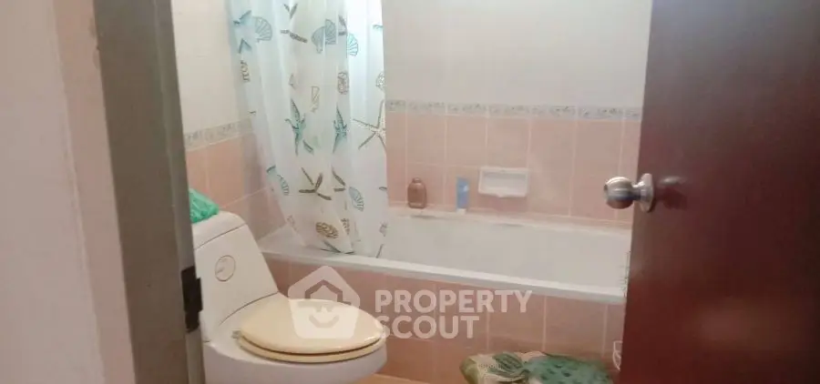 Cozy bathroom with bathtub and decorative shower curtain in a real estate property.