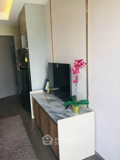 Modern living room with sleek TV stand and vibrant orchid decor