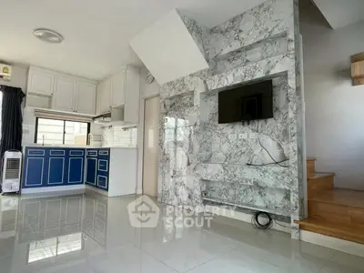 Modern living room with marble accent wall and sleek kitchen in open layout
