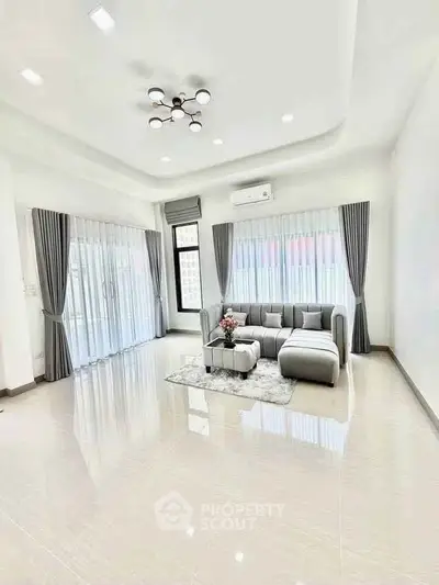 Spacious modern living room with elegant decor and large windows.