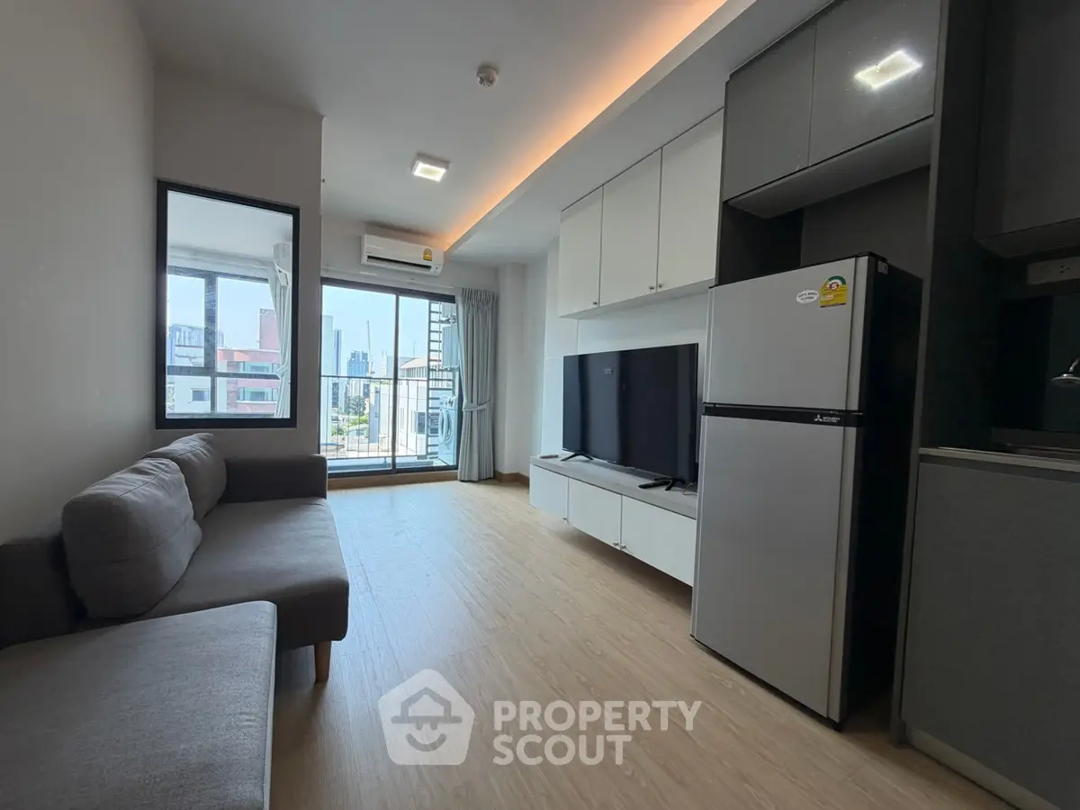 Modern living room with city view, featuring sleek furniture and a spacious layout.