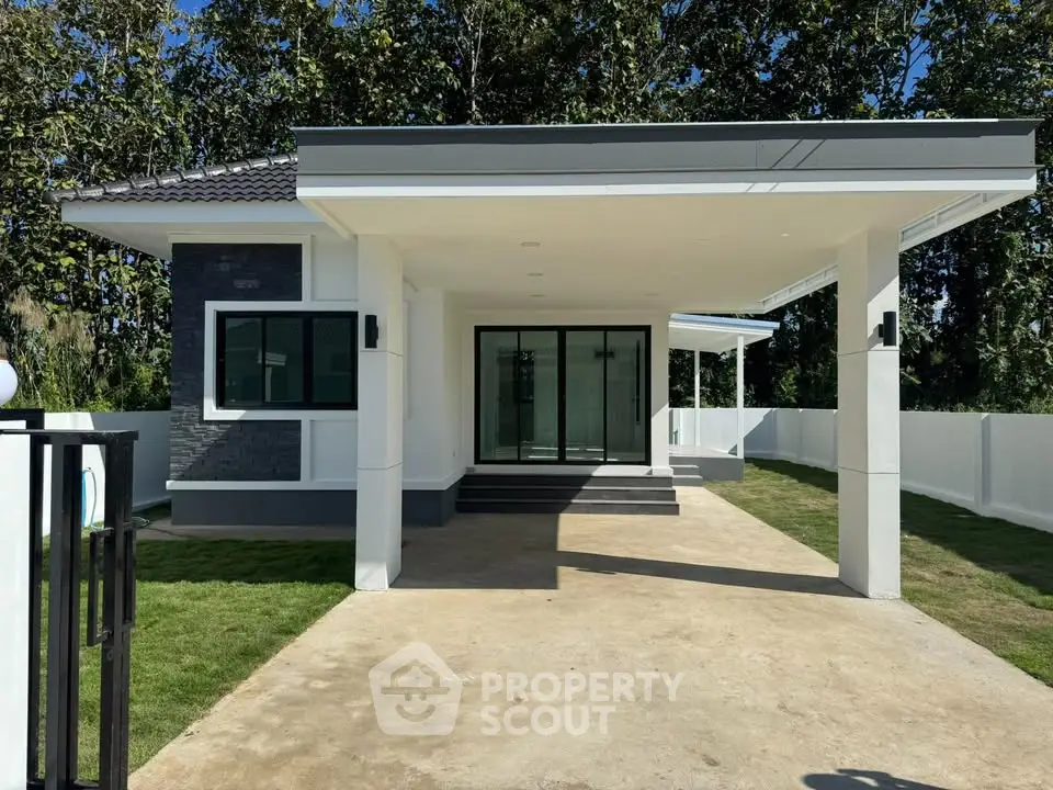 Modern single-story house with spacious driveway and lush greenery