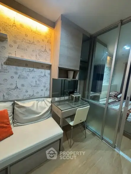 Modern study nook with stylish wallpaper and cozy seating in a contemporary apartment.