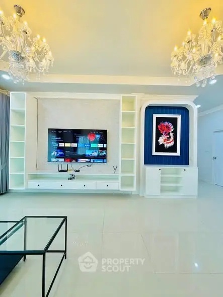 Luxurious living room with elegant chandeliers and modern entertainment setup