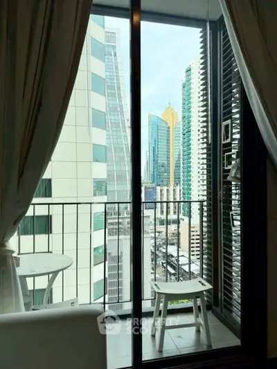 Stunning city view from a modern apartment balcony with sleek glass doors.