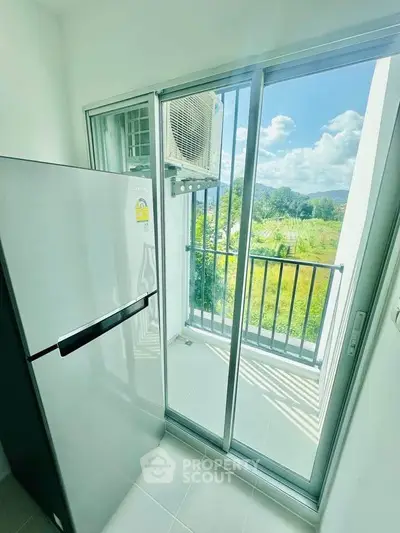 Modern apartment balcony with scenic view and sleek refrigerator