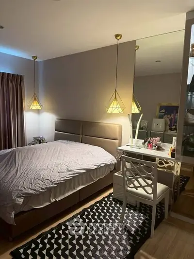 Cozy bedroom with modern lighting and stylish decor, featuring a comfortable bed and elegant vanity area.
