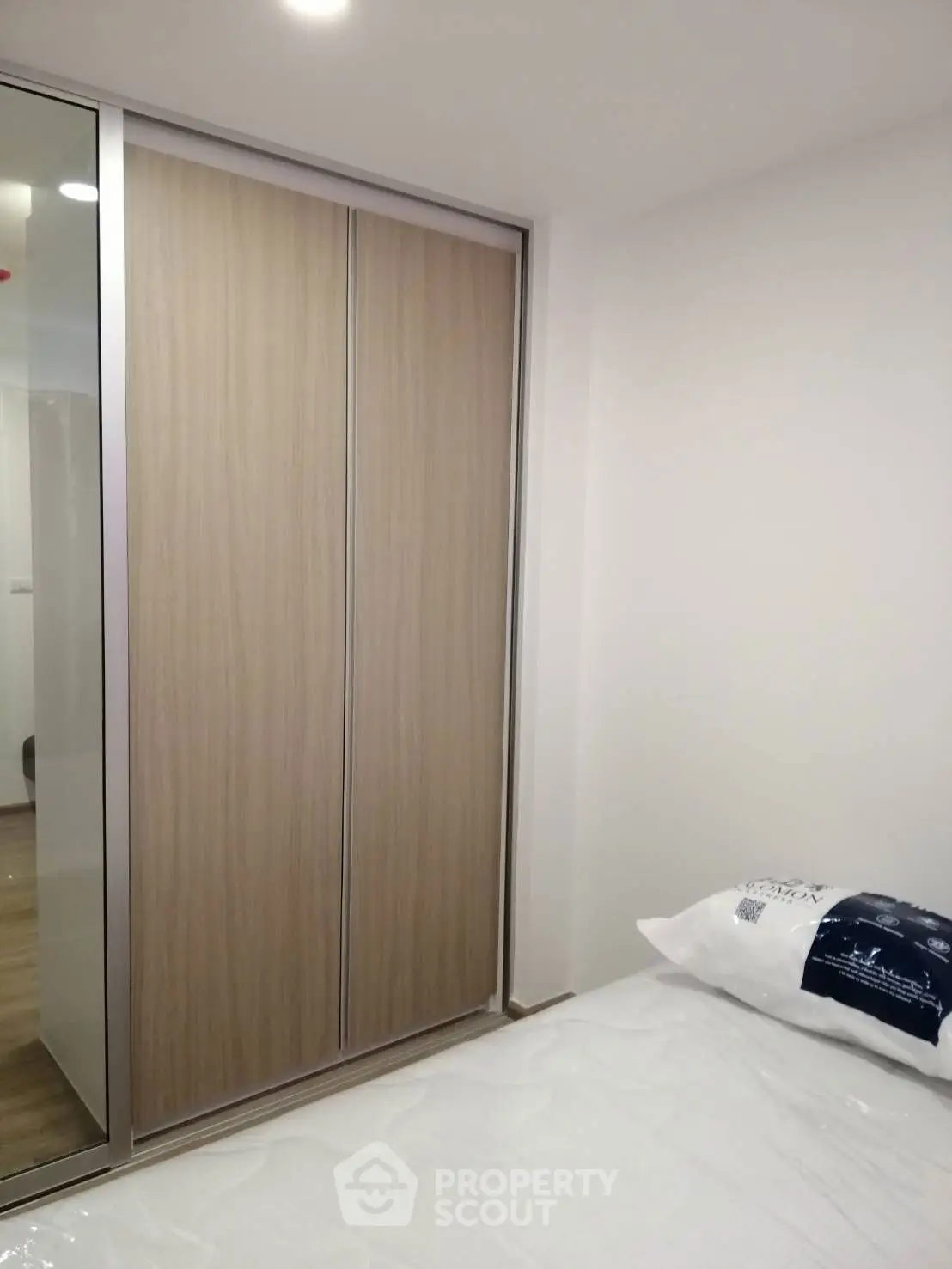 Modern bedroom with sleek wardrobe and cozy bed setup