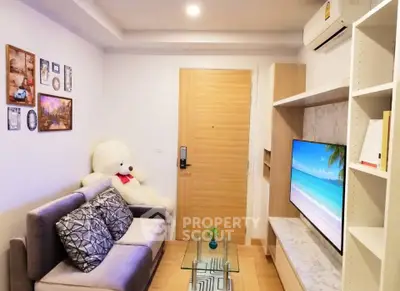 Cozy living room with modern decor and plush teddy bear, featuring a sleek TV setup and air conditioning.