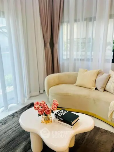 Elegant living room with plush sofa, stylish coffee table, and floor-to-ceiling curtains.