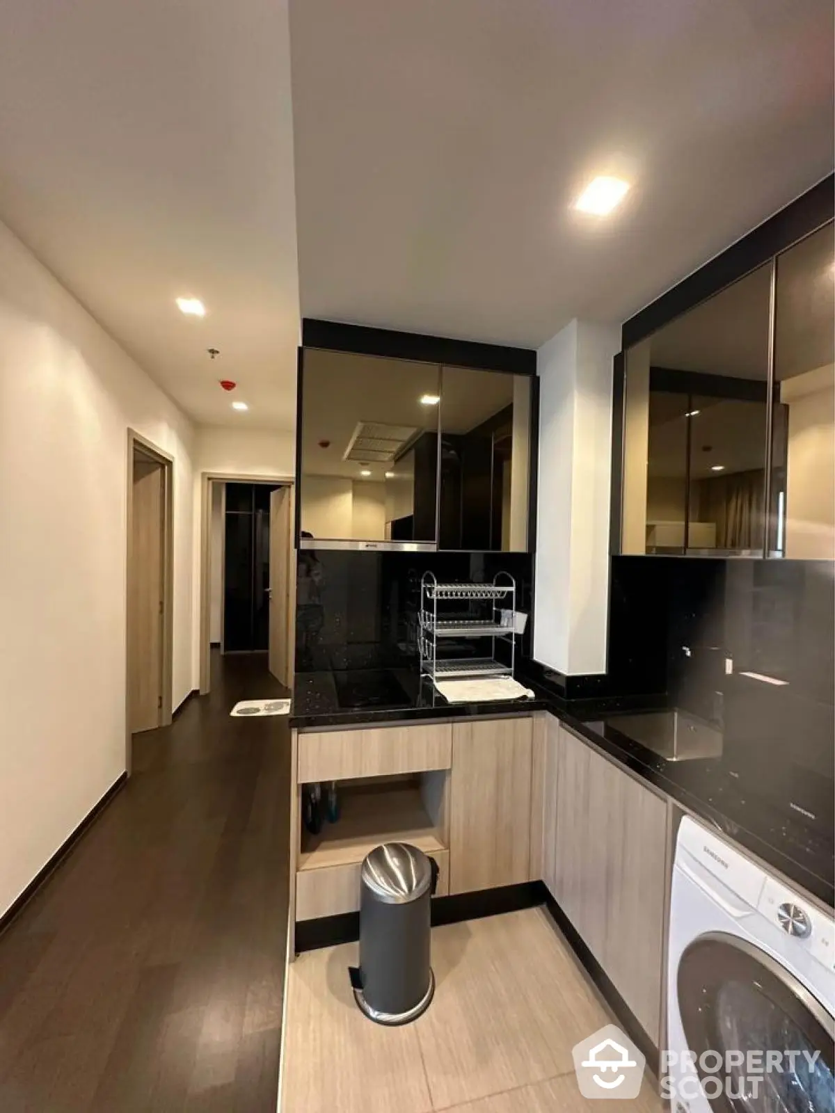 Modern kitchen with sleek black countertops and built-in washing machine