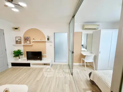 Modern living room with stylish decor and sliding glass partition in a cozy apartment.