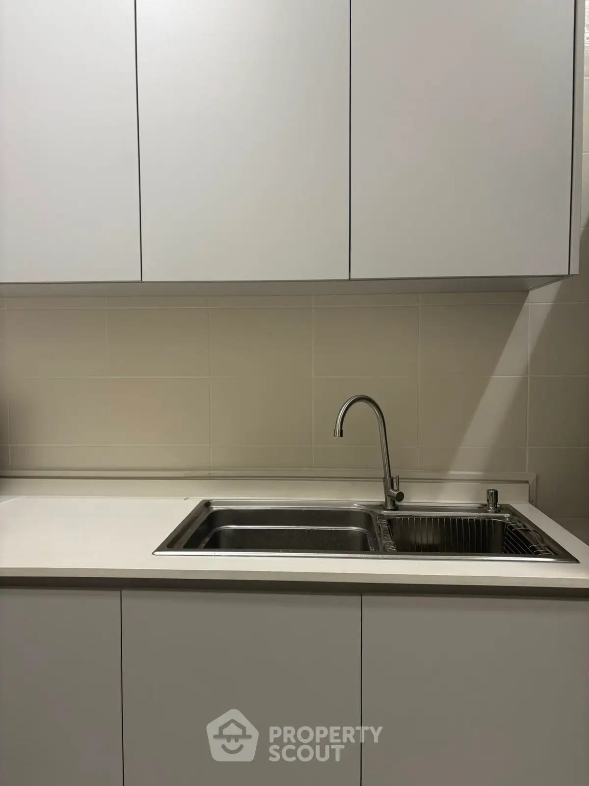 Modern kitchen with sleek cabinetry and stainless steel sink, perfect for contemporary living.