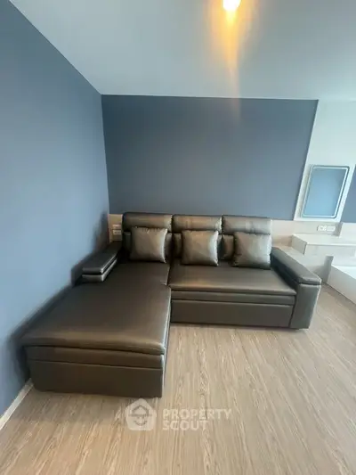 Modern living room with sleek black leather sectional sofa and stylish decor