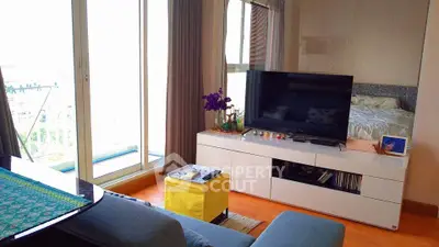 Modern living room with balcony view, stylish furniture, and entertainment setup in a cozy apartment.
