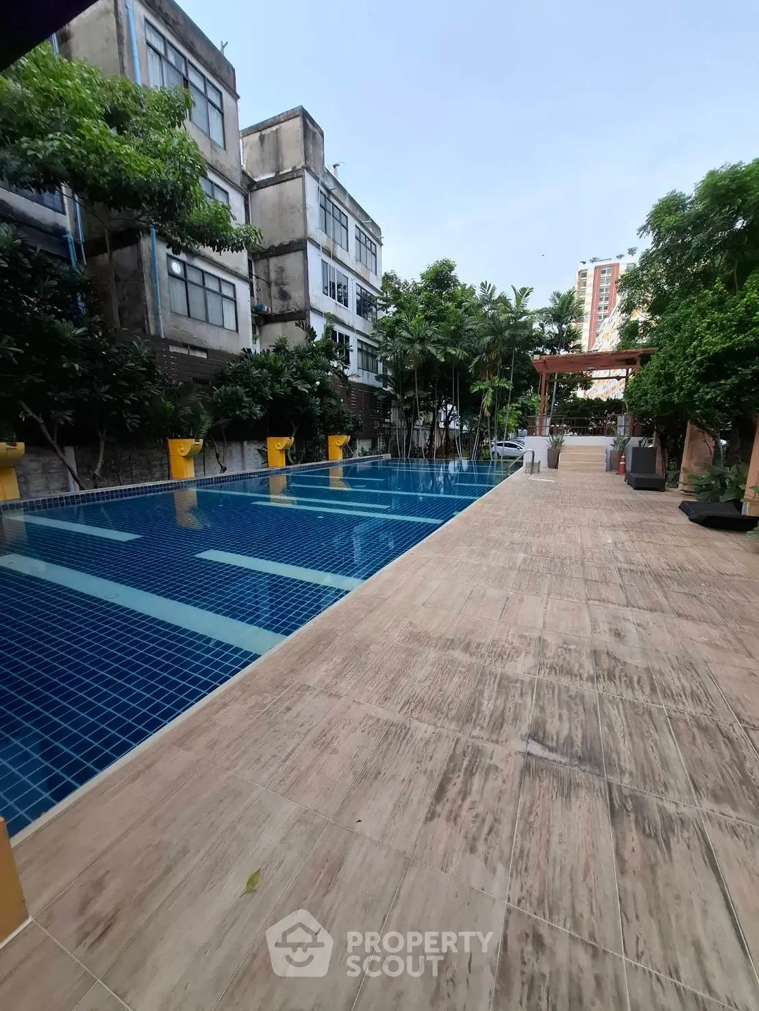 Luxurious outdoor pool area with modern design and lush greenery, perfect for relaxation and leisure.