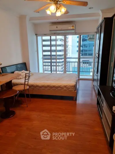 Spacious bedroom with balcony view in modern high-rise apartment
