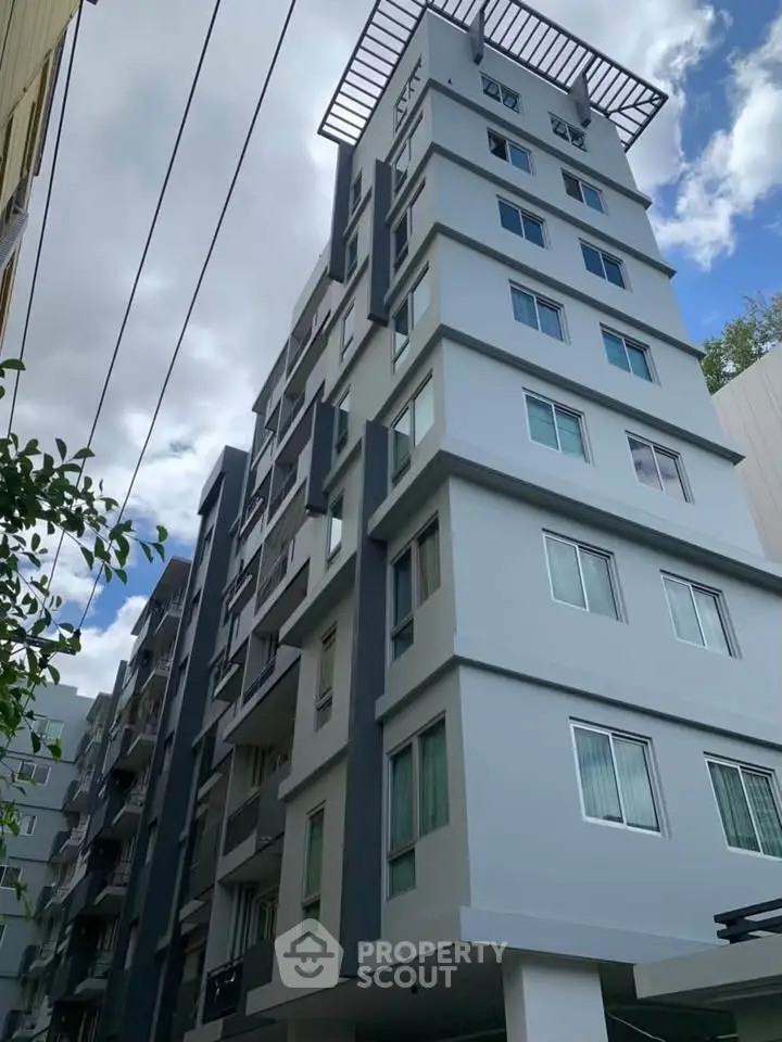 Modern multi-story residential building with sleek design and large windows.